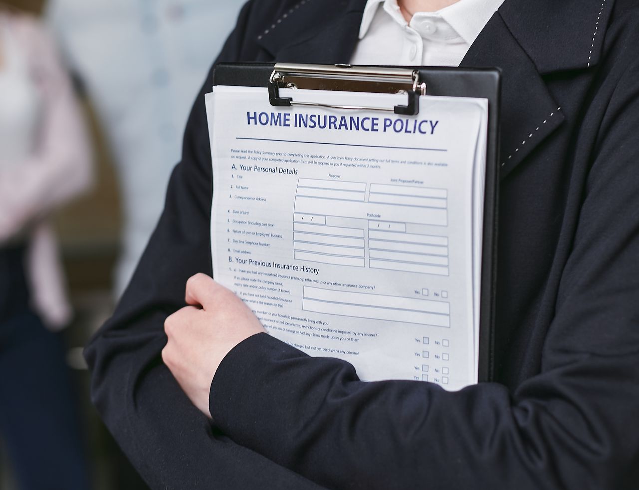 Crafting Captivating Headlines: Your awesome post title goes here Close-up of a person holding a home insurance policy on a clipboard, captured indoors.